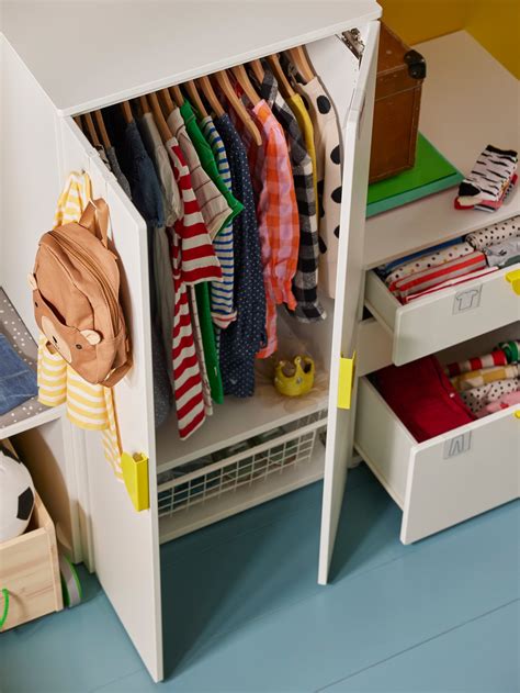 Guardaroba SMÅSTAD in una cameretta con bambino che ripone i vestiti