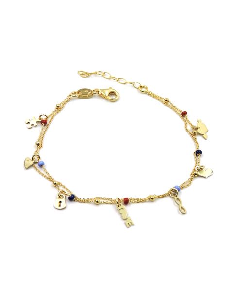 Dettaglio di un bracciale in oro con ciondoli personalizzati