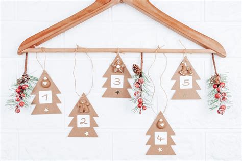 struttura per calendario dell'avvento realizzata con una gruccia e sacchetti decorati