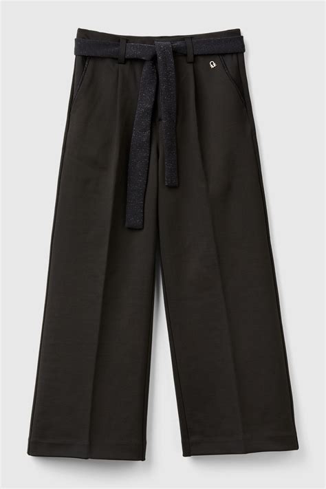 Bambina che indossa pantaloni eleganti in un contesto naturale