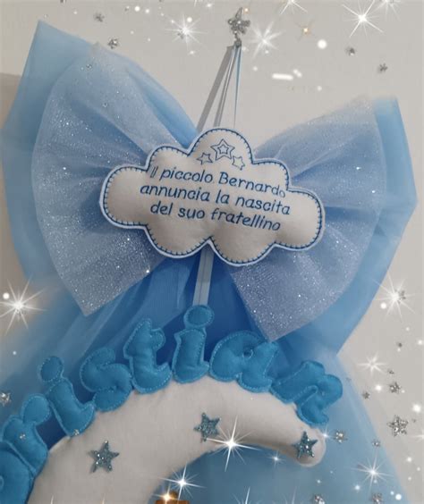 dettaglio di una decorazione personalizzata su fiocco nascita in tulle con nastro e ciondolo