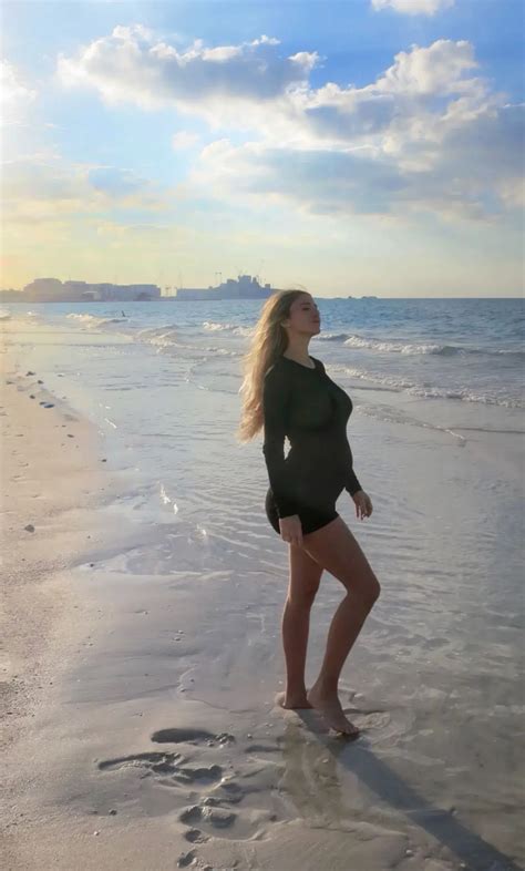 Donna incinta che indossa un costume premaman elegante in riva al mare