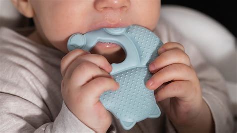 Bambino che si morde le mani per la dentizione