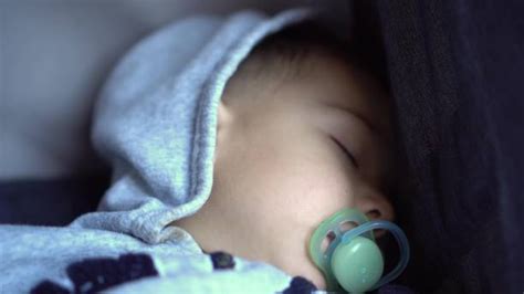 Icona di un bambino che dorme serenamente con un ciuccio