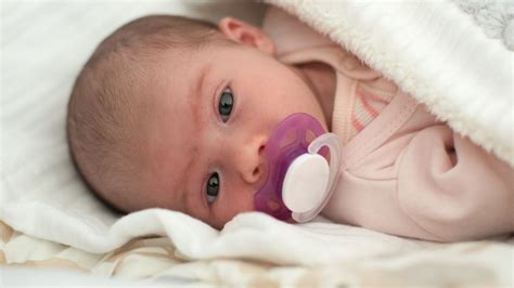 Neonato che succhia un ciuccio