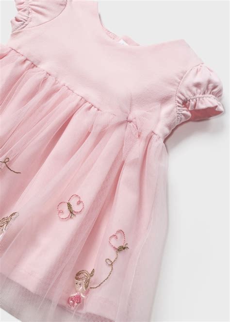 Neonata sorridente con vestito festivo e accessori coordinati
