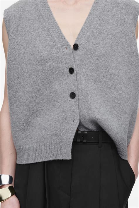 dettaglio di un gilet in lana lavorato a maglia con bottoni in legno