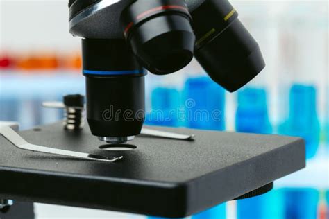 Microscopio con provette e strumenti di laboratorio per PMA