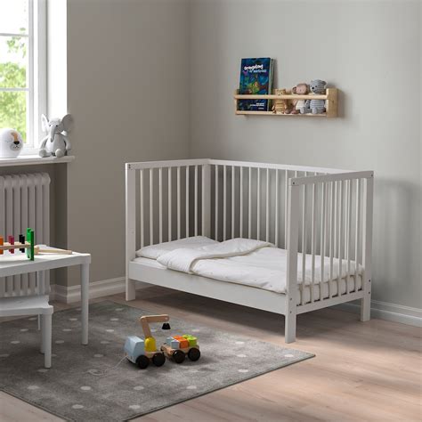 Una cameretta per bambini ben arredata con un lettino IKEA dallo stile minimalista e colori accoglienti.
