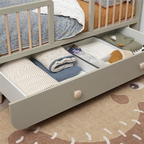 Dettaglio di un lettino IKEA con cassetti integrati per l'organizzazione della biancheria e dei giochi.