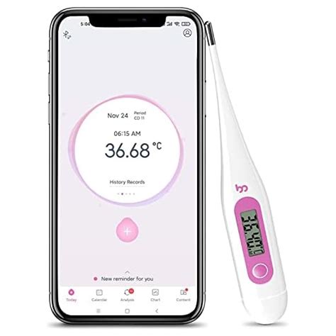 Donna che misura la temperatura basale con un termometro e registra su app