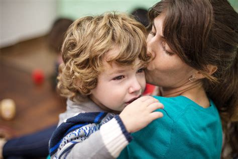 Bambino che piange mentre il genitore lo saluta al nido