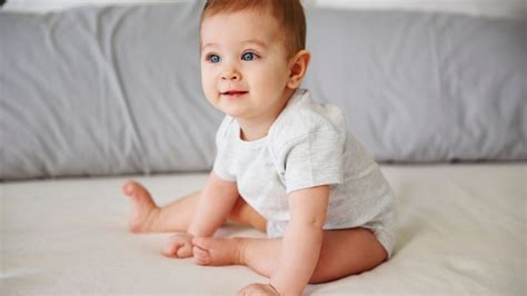 Bambino di sei mesi che impara a stare seduto