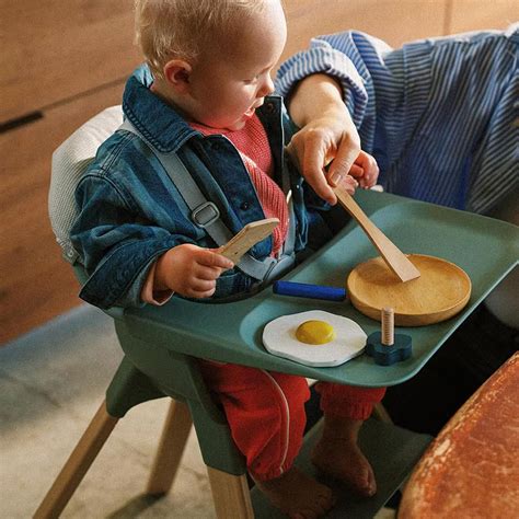 Bambino che gioca con il vassoio rimovibile di un seggiolone