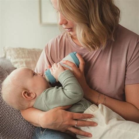 Mamma preoccupata mentre tiene il biberon e il bambino