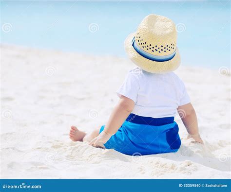 bambino sulla spiaggia con cappello e crema solare