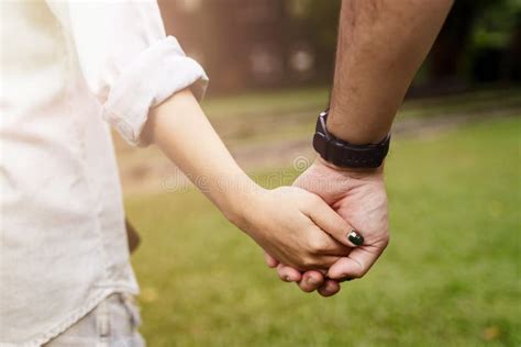 Coppia che si tiene per mano, con un simbolo di famiglia e bambino in secondo piano