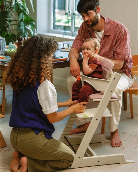 Famiglia felice attorno a un tavolo con bambino nel seggiolone CAM