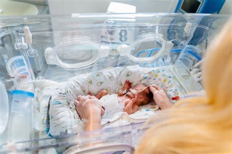 Infermiere che monitora un neonato in incubatrice