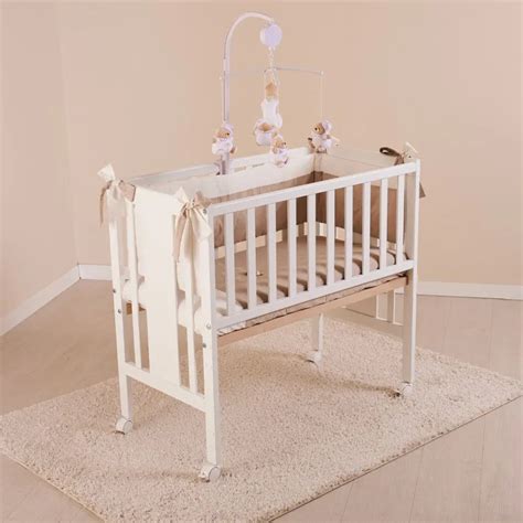 Culla co-sleeping in legno a fianco di un letto matrimoniale