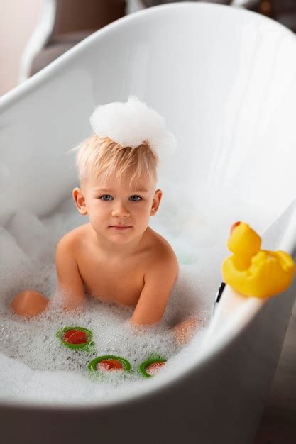 Bambino che gioca con giocattoli colorati nella vasca da bagno