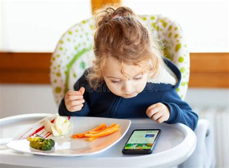 Bambino sorridente sul seggiolone mentre mangia