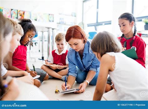 immagine di un insegnante che interagisce con un gruppo di bambini in un'attività creativa