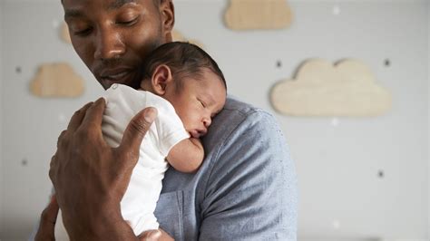 un padre che culla il suo neonato per farlo addormentare
