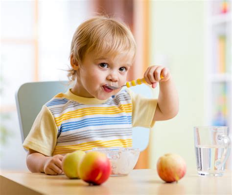 Bambino che mangia con gusto sul seggiolone
