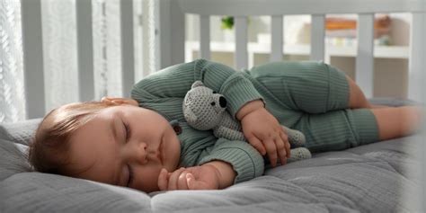 Bambino che dorme in posizione supina in una culla sicura