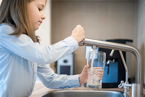 Famiglia che beve acqua dal rubinetto con depuratore
