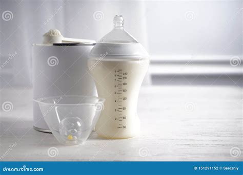 Tavola con biberon, misurino e ingredienti per latte in polvere