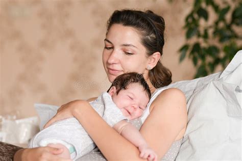 neonato che riposa serenamente tra le braccia della mamma