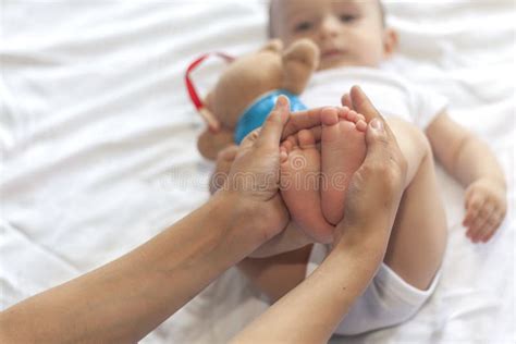 genitore che massaggia le gambe del proprio neonato
