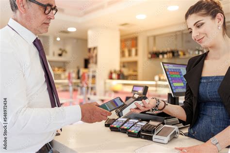 Un commesso sorridente che aiuta una cliente a scegliere un passeggino