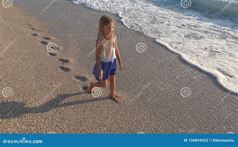 bambino che cammina sulla sabbia