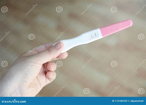 donna che tiene in mano un test di gravidanza