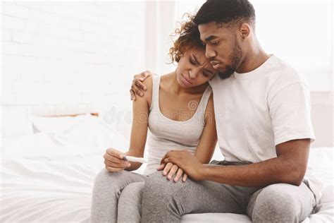 coppia triste che guarda un test di gravidanza negativo