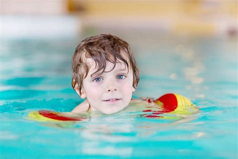 Un bambino che indossa braccioli in una piscinetta