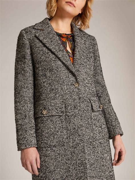 Donna con cappotto in tweed e sciarpa tartan