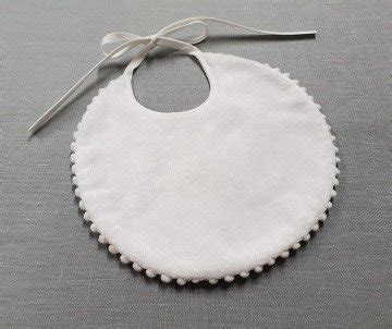 Un elegante bavaglino per neonato decorato con dettagli in tulle e ricami artigianali