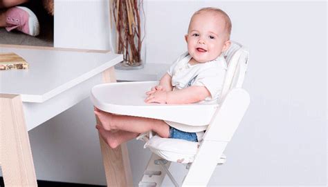bambino seduto in un seggiolone ergonomico durante il momento della pappa