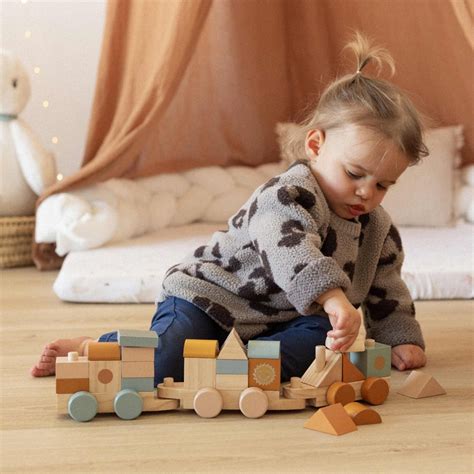 Bambino che trascina un trenino di legno