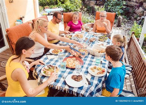 Famiglia che mangia insieme a tavola, con il bambino che assaggia