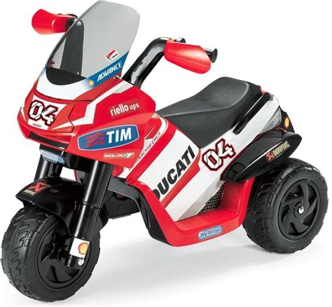 Bambino che gioca con una moto Peg Perego all'aperto