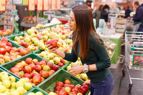 Donna che sceglie frutta e verdura fresche al mercato