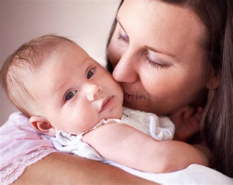 Neonato che riceve un bacio dalla madre