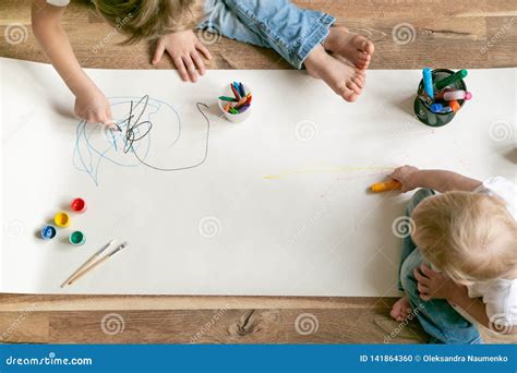 Bambini che dipingono con spruzzini su un grande telo all'aperto