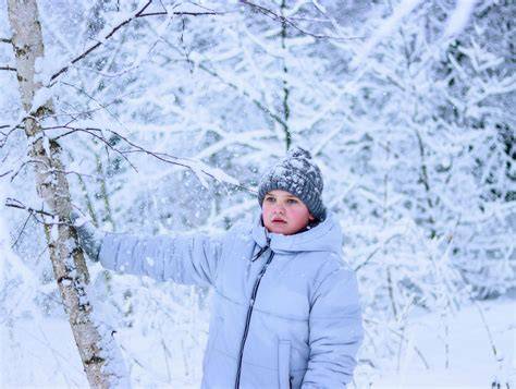Bambino con abbigliamento invernale in montagna