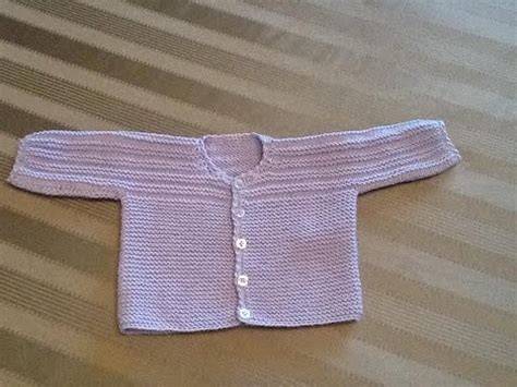Manine di neonato che afferrano un golfino lavorato a maglia